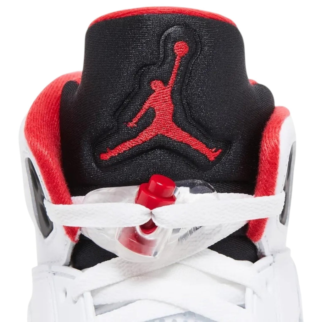Close-up of a red, black, and white sneaker with a prominent logo on a white background