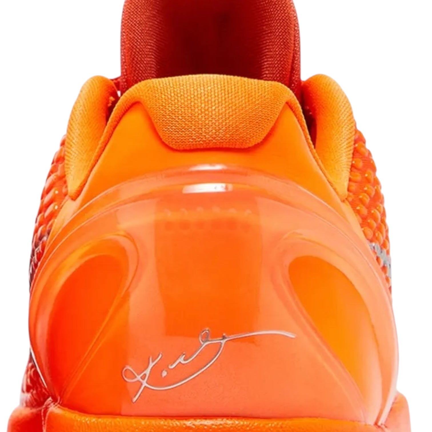 Close-up of an orange sneaker with a signature on the sole against a white background