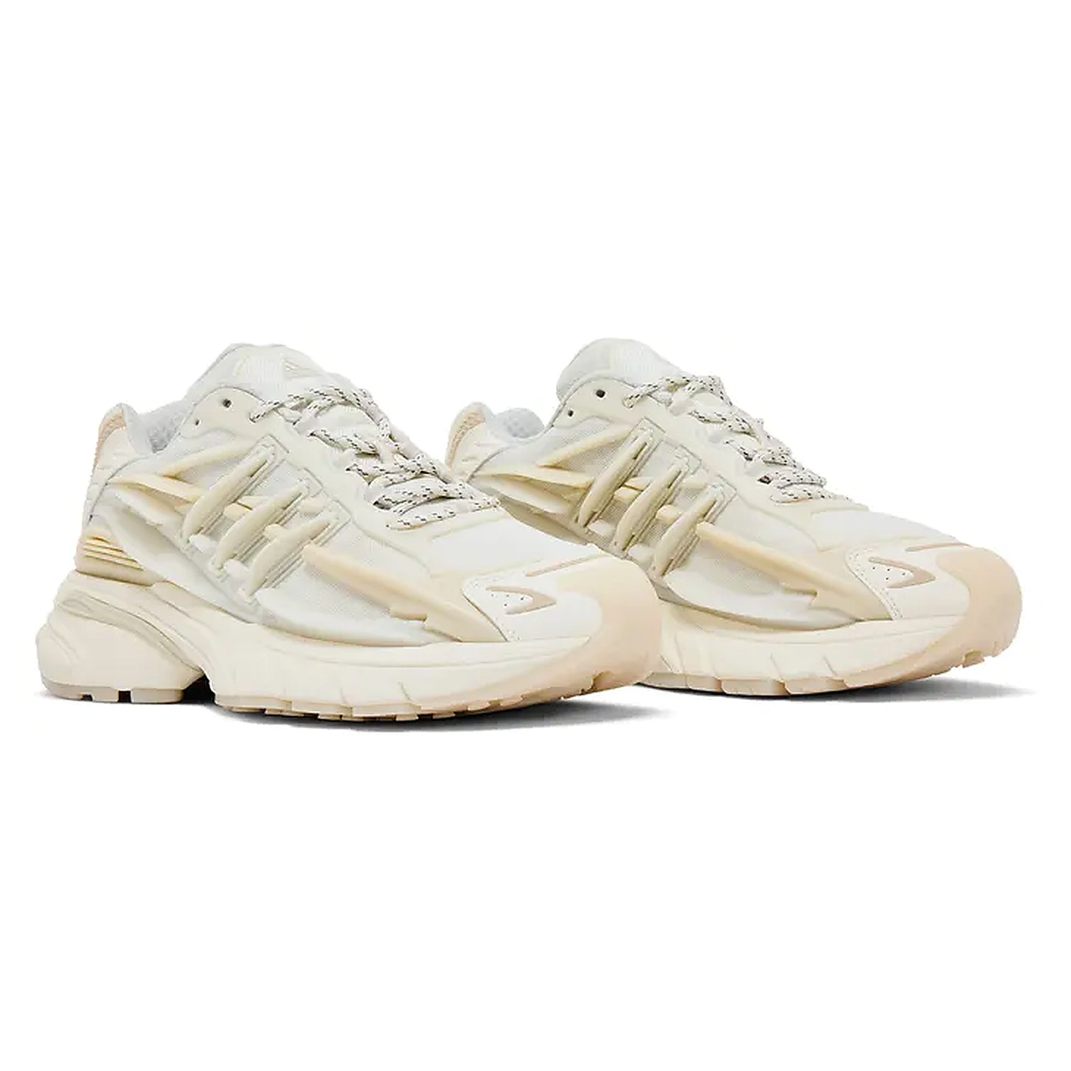 A pair of chunky, multi-layered athletic sneakers in a cream and beige colorway, displayed against a clean white background.